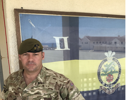 A Sergeant in front of flag